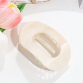 Close-up of beige leopard print hair claw clip with cutout design on white surface - Beige Smudge