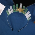 Detail of green and white crystal crown with golden triple moon on dark blue fabric - Clear Quartz + Green Aventurine