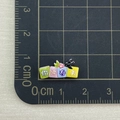 Mini resin nail art accessory measuring 2.8cm on a black metric cutting mat grid - Hello Spring Square