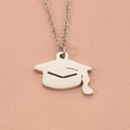 Elegant silver graduation cap pendant necklace displayed on soft pink silk fabric - Steel