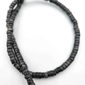 Primo piano di perline distanziatrici in pietra naturale su una collana fatta a mano - 2*4mm/filo circa 130 pezzi / Nero