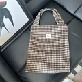 Borsa tote a quadri marroni con etichetta sozakka su sfondo di pelle nera lucida - Caffè a scacchi