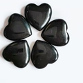 Polished heart-shaped black obsidian stones arranged in a decorative floral pattern - Obsidian
