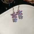 Dettaglio di orecchini a fiore con zirconi rosa su piatto di ceramica bianca lucida - Orecchini a gancio con fiori / Argento-Rosa