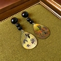 Detailed macro view of retro Chinese style teardrop earrings with black beads and shell - Silver Needle - Ink Painting Water Drop Ear Drops