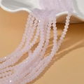 Close-up of 4mm faceted opal pink wheel beads on a white tray for jewelry making - Opal Crystal Pink