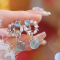 Eleganti orecchini a sirena con zircone blu e perle indossati da una modella - Orecchini a Clip Bolla di Sirena