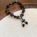 Close-up of vintage acrylic coffee bean beads and metal tag on a handmade bracelet - Bracelet - Black & Coffee