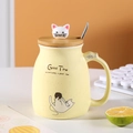 Yellow ceramic cute cat mug with a wooden lid and metal spoon for breakfast coffee - Yellow
