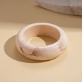 Detailed view of pink resin bangle with dark marble texture on warm beige background - White-Round