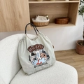 Close-up of light grey nylon tote bag with cute cat illustration on a cozy sofa chair - Light Grey Happy Cat