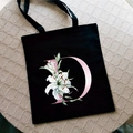 Bolso tote de lona negra con letra D rosa y estampado floral de lirios blancos - Letra D / Negro