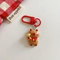 Détail d'un porte-clés ours avec trophée doré et fermoir mousqueton rouge sur fond blanc - Capybara - Trophée