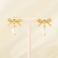 Detail of gold bow earrings with a white pearl drop displayed on a white stand - Gold Silk Bow (KE113931-KFC)