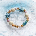 Ceramic ocean theme bracelet with blue starfish and small fish beads on a glass plate - Ocean Small Fish Style (1615-03) / Blue and Beige Mix