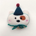 Detail shot of plush dog brooch featuring a blue hat and green bow, size 7cm by 6.5cm - Brooch Style / Green Hat Beige Dog
