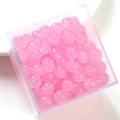 Close-up of pink glass jelly beads in a plastic box for DIY jewelry making - Pink Apple Bead