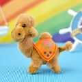 Detailed macro view of a cute brown camel plush toy keychain featuring an embroidered orange saddle - Tilting Head Camel / Orange / 15cm