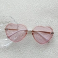 Pink heart-shaped children's sunglasses with gold frame and bee detail on white wall - Metal Bee Heart Shape