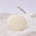 White shell shaped scented candle with natural tag on aesthetic wrinkled paper - Shell