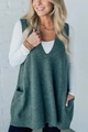 Detail view of dark green V-neck knit vest showing side pockets and soft wool texture - S / Malachite green