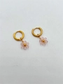 Handmade gold hoop earrings with faceted pink crystal flower charms on white background - Transparent Pink