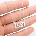 Detailed close-up of 1981 gothic font year pendant on a polished stainless steel chain - 1981 / Steel