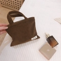 Texture détaillée du mini sac à main en velours côtelé marron avec étiquette Simple Wish - Violation De L'arrière-plan - Lancôme / café