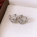 Detail shot of silver twisted knot hoop earrings featuring a polished metallic finish - Ear Buckle / Silver