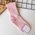 Close-up of pink ribbed cotton socks with EMPOLE tag on a minimalist grid background - One Size / Light Pink