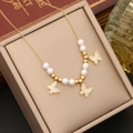 Collier papillon doré élégant avec pendentifs en nacre et perles sur boîte à bijoux - Modèle Papillon