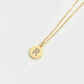 Minimalist gold necklace featuring a round pendant with sparkling gemstone letter R - Letter R