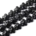 Vista macro di perle in ceramica nera a forma di fiore per la creazione di gioielli - Nero