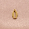 Detailed view of gold number 0 pendant in polished stainless steel on soft pink fabric - Gold Number 0