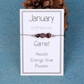January Garnet birthstone bracelet with raw dark red stones on a gray braided cord - January/Garnet