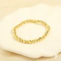 Detailed view of irregular gold beaded stretch bracelet on a white textured shell tray - BR1683-F/Gold Engraved Splicing Beads