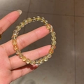 Detailopname van gele citrien kralenarmband met een zirkonia bloem metalen bedel - Lichtgeel Kristallen Bol (Exquise Geschenkdoos)
