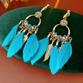 Détail de boucles d'oreilles bohèmes avec plumes bleues, anneaux dorés et feuilles - Style à Clip / Vert