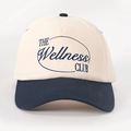 Detail of THE Wellness CLUB embroidery on two-tone cream and navy cotton baseball cap - One Size / Cream/Navy Blue