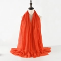 Red crinkled cotton linen scarf with fringe edges displayed on a white model bust - Crimson