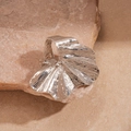 Dettaglio macro dell'anello in metallo argentato a forma di ventaglio con finitura a specchio - Argento