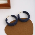Close-up of blue denim hoop earrings with white polka dots and gold-plated metal hooks - Dark Blue