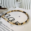 Detalle de diadema de acetato con estampado de leopardo sobre una revista de diseño - Carey Claro - Forma de Gafas