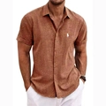 Close-up of brick red linen polo shirt featuring white embroidered horse logo detail - S / Tops / Brown