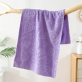Soft purple coral fleece towel with embossed bear and flower patterns hanging on wood - Purple