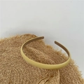 Minimalist light yellow fabric headband with non-slip lining displayed on a straw hat - Yellow