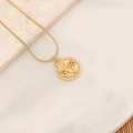 Nahaufnahme des Widder-Zodiac-Goldanhängers mit Widderkopf-Gravur an einer Schlangenkette - Widder