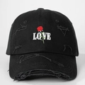 Detailed embroidery of white LOVE text and a red rose on a distressed black baseball cap - One Size / Black