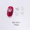 Detailed view of mini 7x6mm silver hollow butterfly charms on deep red nails - Silver Mirror Butterfly (8811)