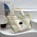 Off-white canvas tote bag featuring black floral print and NKK ART STUDIO typography - Off White